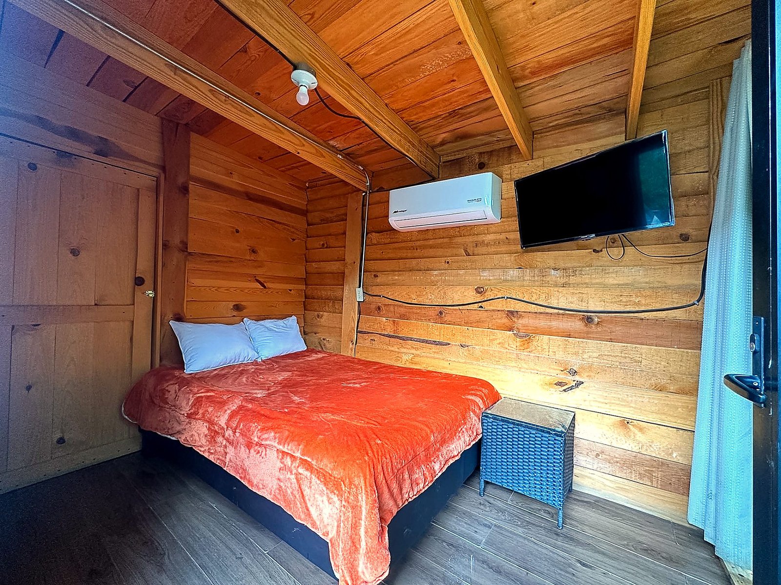 Recámara acogedora de AURORA BOREAL con cama, muros de madera cálida, Smart TV y climatización
